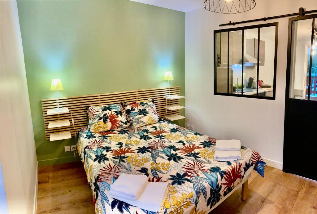 安锡Appartement ALBIGNY Centre Lac Annecy的卧室里有一张铺着花卉床罩的床