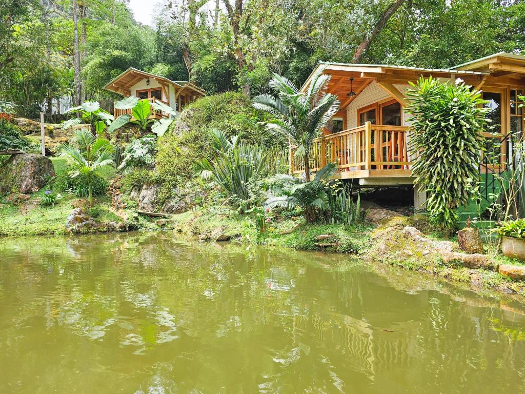 una casa junto a un río con una casa en La Mercedes Cattaleya Hostal BY MH en Yumbo