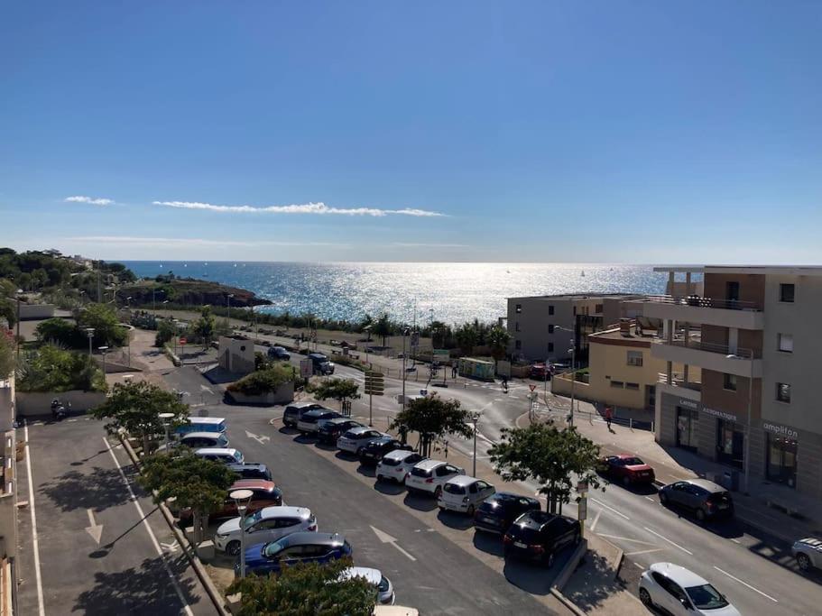 - un parking avec des voitures garées à côté de l'eau dans l'établissement Appartement T3 Vue Mer La Corniche Sète, à Sète