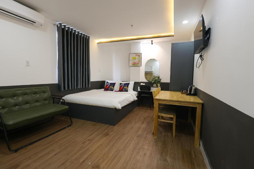 a room with a bed and a couch and a table at Ruby Star Hotel Nam Quoc Cang in Ho Chi Minh City
