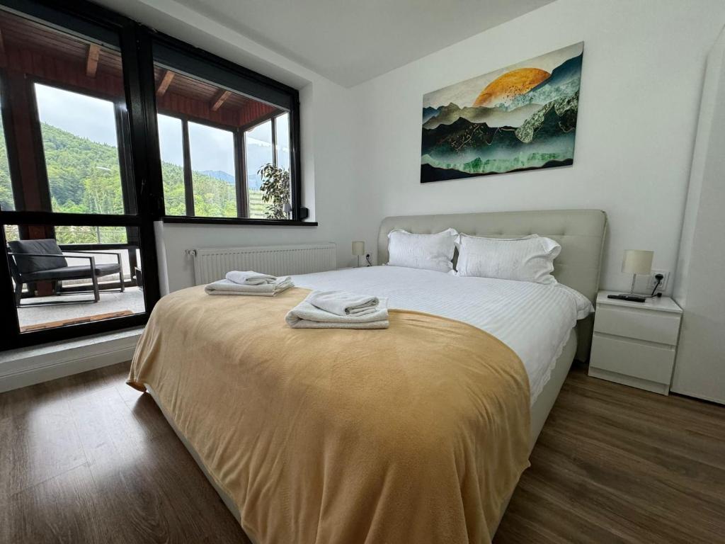 a bedroom with a bed with two towels on it at Best View Penthouse - Terrace - 2 Bathrooms - Free Parking in Sinaia