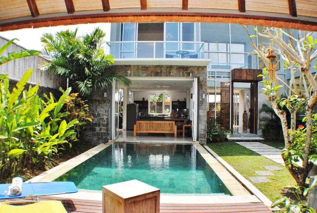 a swimming pool in the middle of a garden at Villa Efes Bali in Seminyak