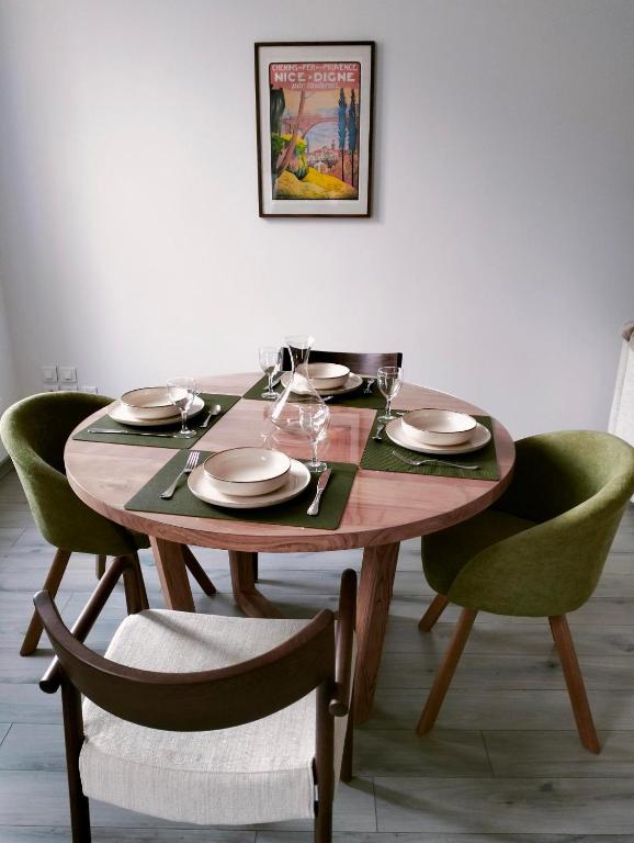 une table en bois avec des assiettes et des verres à vin dessus dans l'établissement La Provence vous Attend - 2ème étage, à Digne-Les-Bains