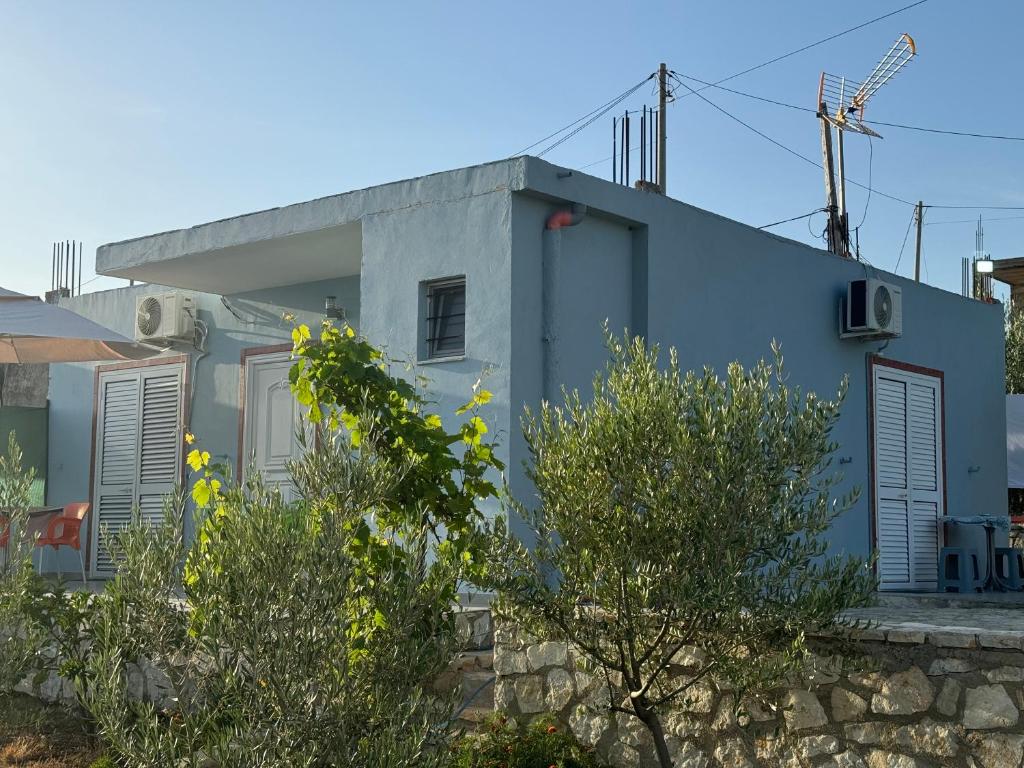 a blue house with trees in front of it at Vila Bedro in Sarandë