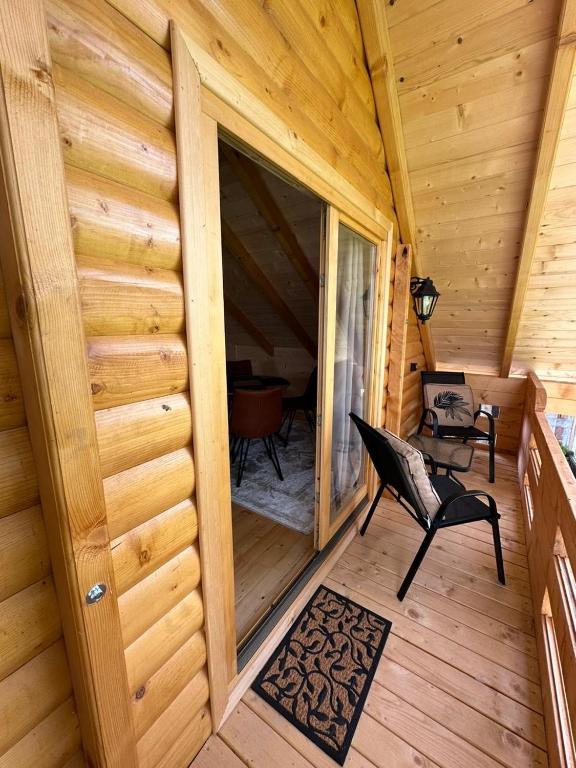 a screened in porch of a log cabin with a chair at Brvnara La Forêt in Žabljak