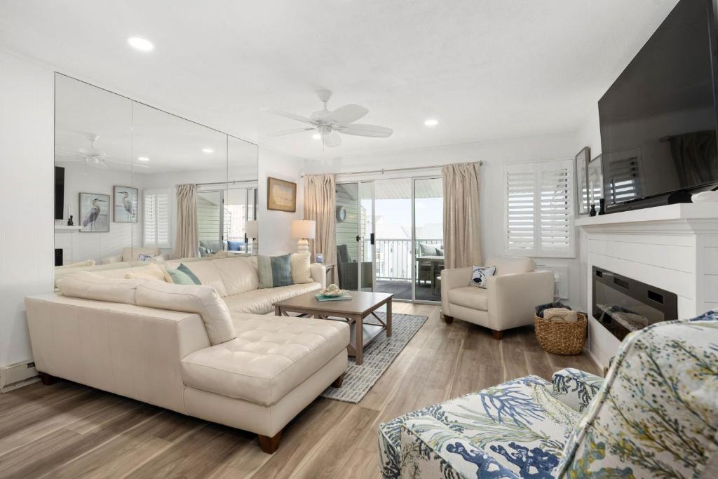 a living room with white furniture and a fireplace at 2 Bedroom Bayside Condo with Pool in OCMD in Ocean City