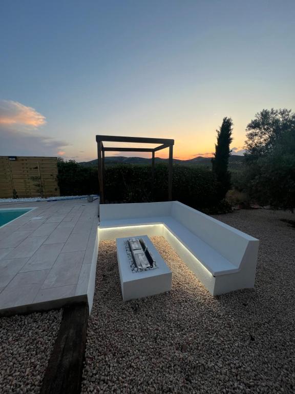 a bench sitting next to a pool with a gazebo at Village Díaz - Fernández in Herencia