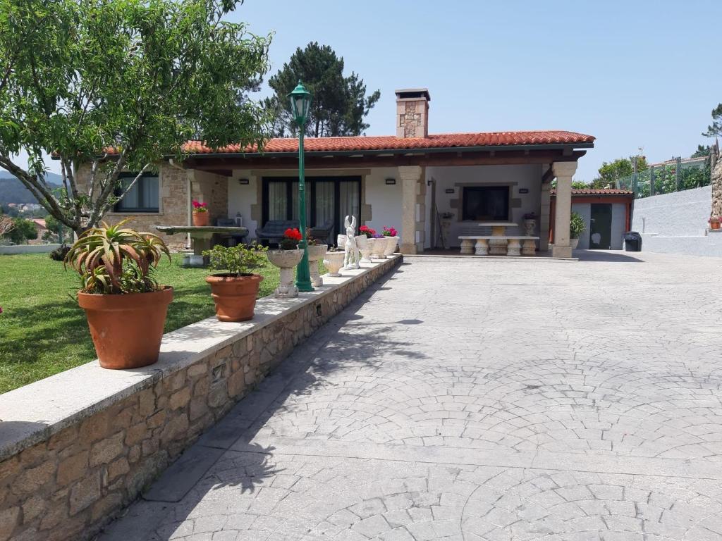 a house with potted plants on a stone wall at Casa con vistas al mar in Noya