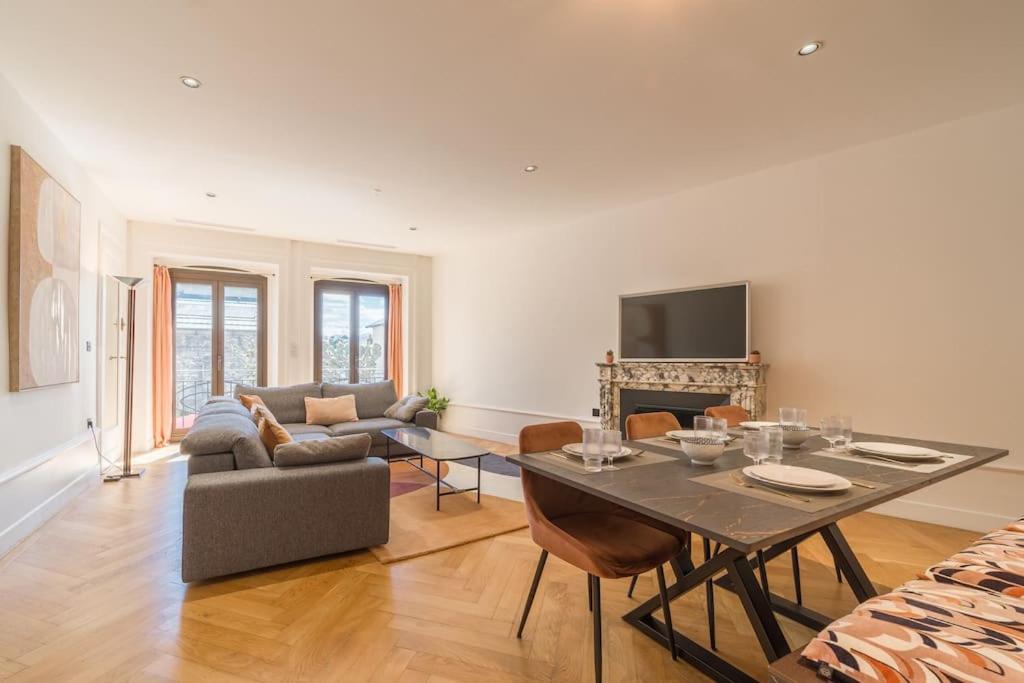 un salon avec une table et un canapé dans l'établissement Astoria Haussmannien - Appartement de caractère, à Aix-les-Bains