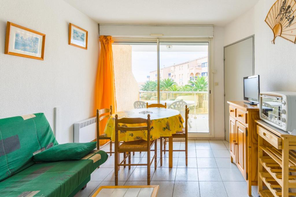 uma sala de estar com uma mesa e um sofá em Lagrange Vacances Les Résidences em Sainte-Marie-Plage