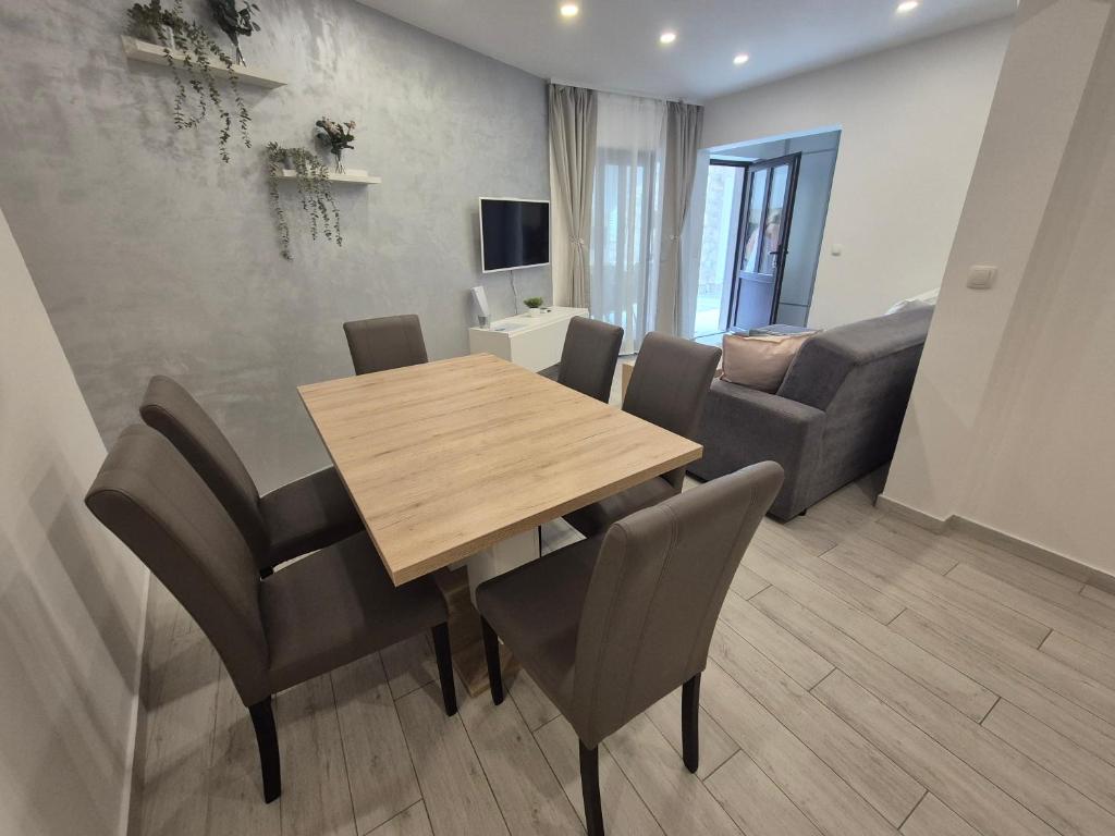 a dining room with a table and chairs and a couch at Apartment Rika in Omiš
