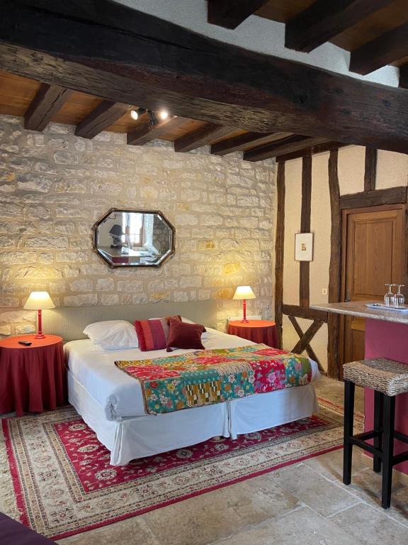 a bedroom with a bed and two tables and a mirror at La Maison d'Alienor, Gite à Chablis in Chablis