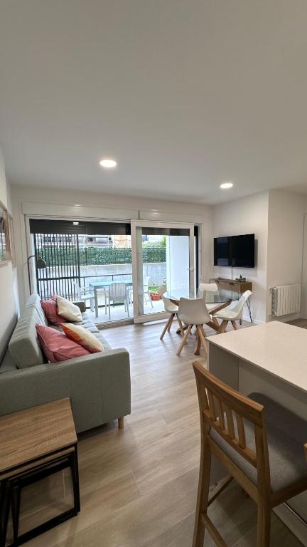 a living room with a couch and a table at Apartamento con jardin Long Beach Loredo in Loredo