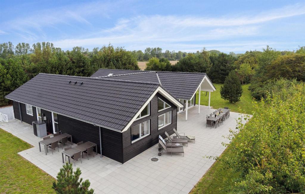 an overhead view of a black house with tables and benches at Lovely Home In Væggerløse With Sauna in Marielyst