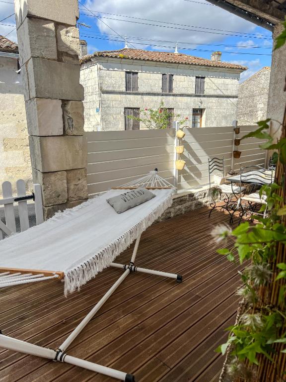 - un hamac sur une terrasse avec un bâtiment dans l'établissement Maison proche de l'Estuaire, à Brie-sous-Mortagne