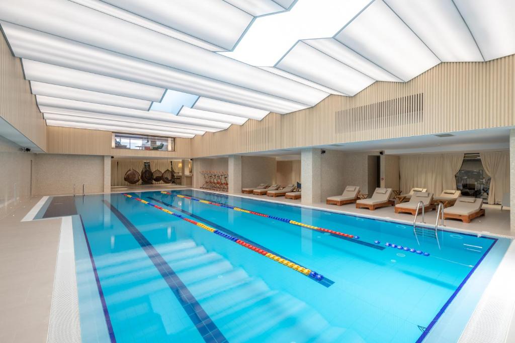 een binnenzwembad met een groot plafond bij Spa & Pool - Studio Apartments 365 in Tirana