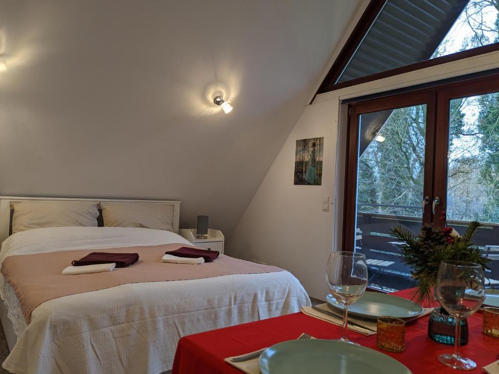 a bedroom with a bed and a table with wine glasses at Urlaub zwischen Natur und Kunst in Worpswede