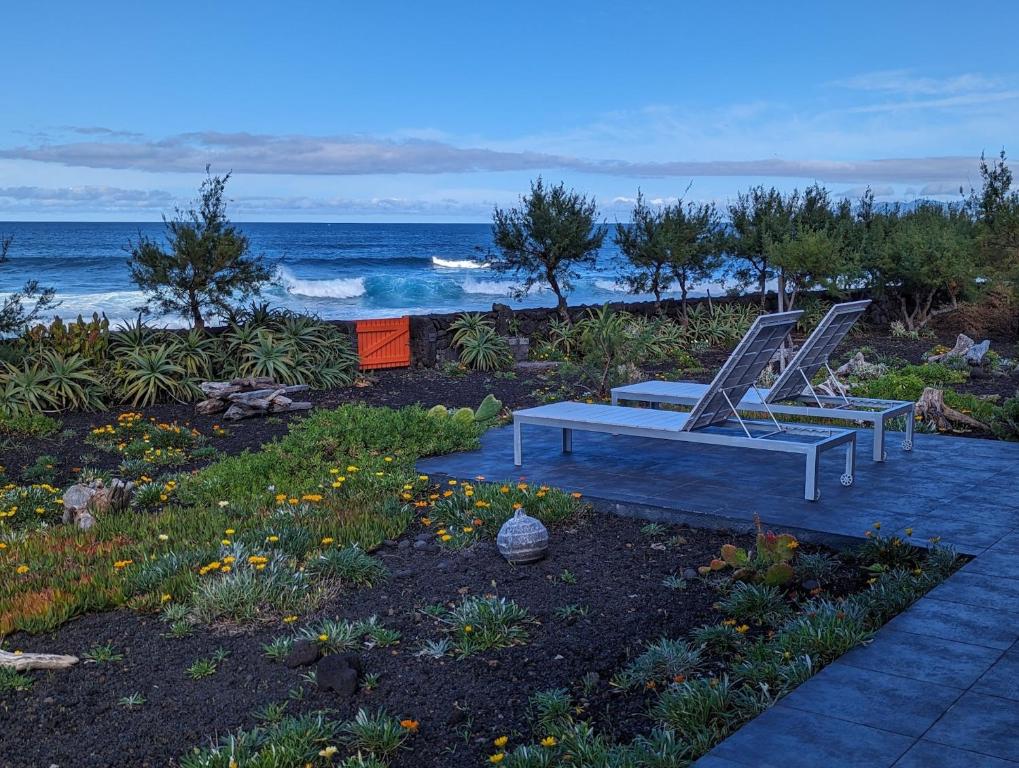 two chairs and a bench on the beach at Casa Baleia Laranja Ocean-Front in Madalena