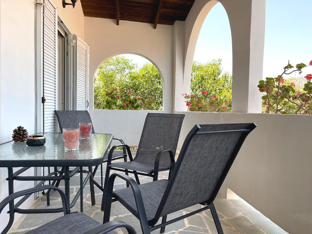 a table and chairs on a patio with two windows at Sounio Poseidon Villa in Sounio