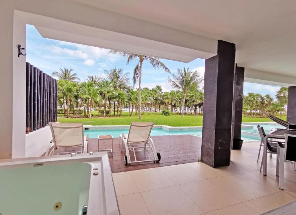 a patio with chairs and a swimming pool at Casamarmareazul in Playa del Carmen