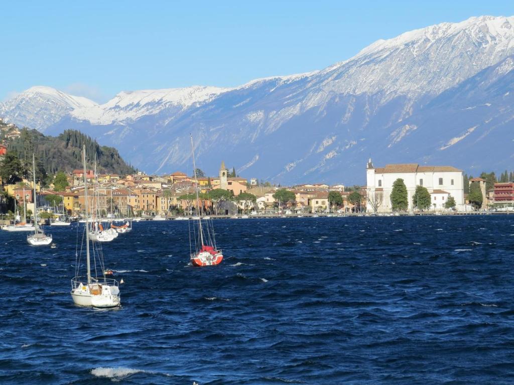 a group of boats in a body of water with mountains at Casabb in Toscolano Maderno