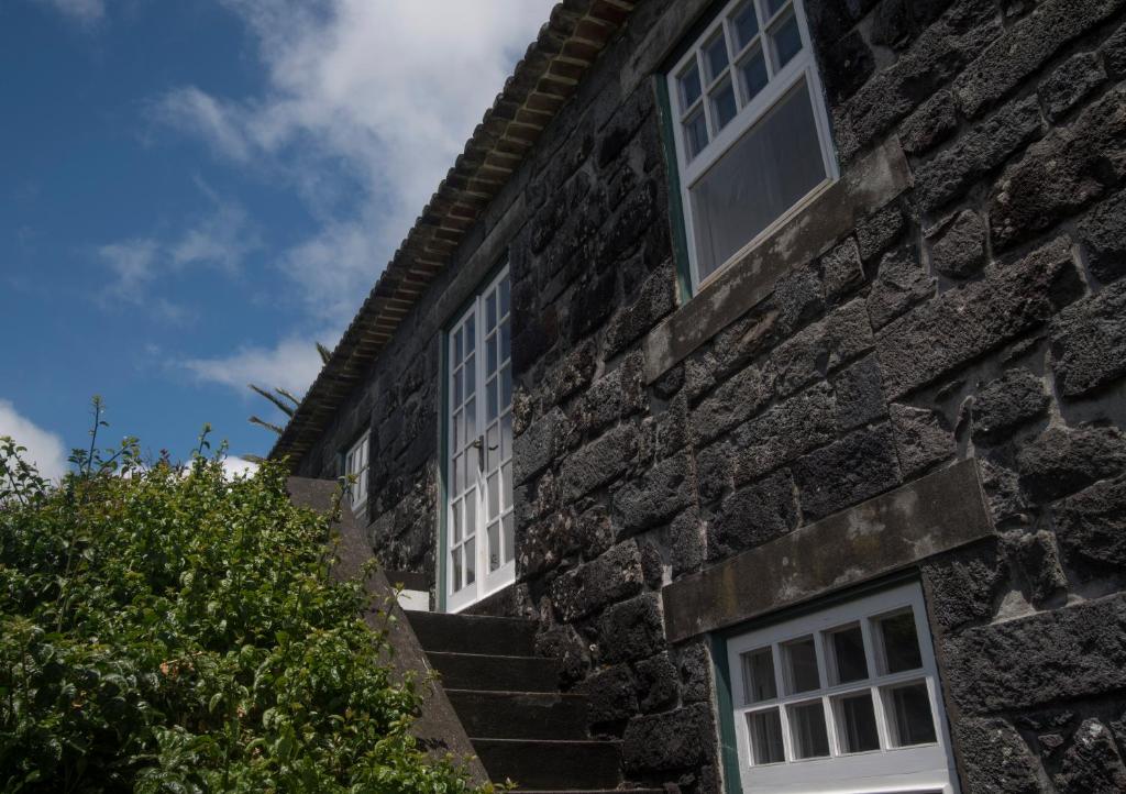a stone building with two windows and stairs at Quinta das Buganvílias in Castelo Branco
