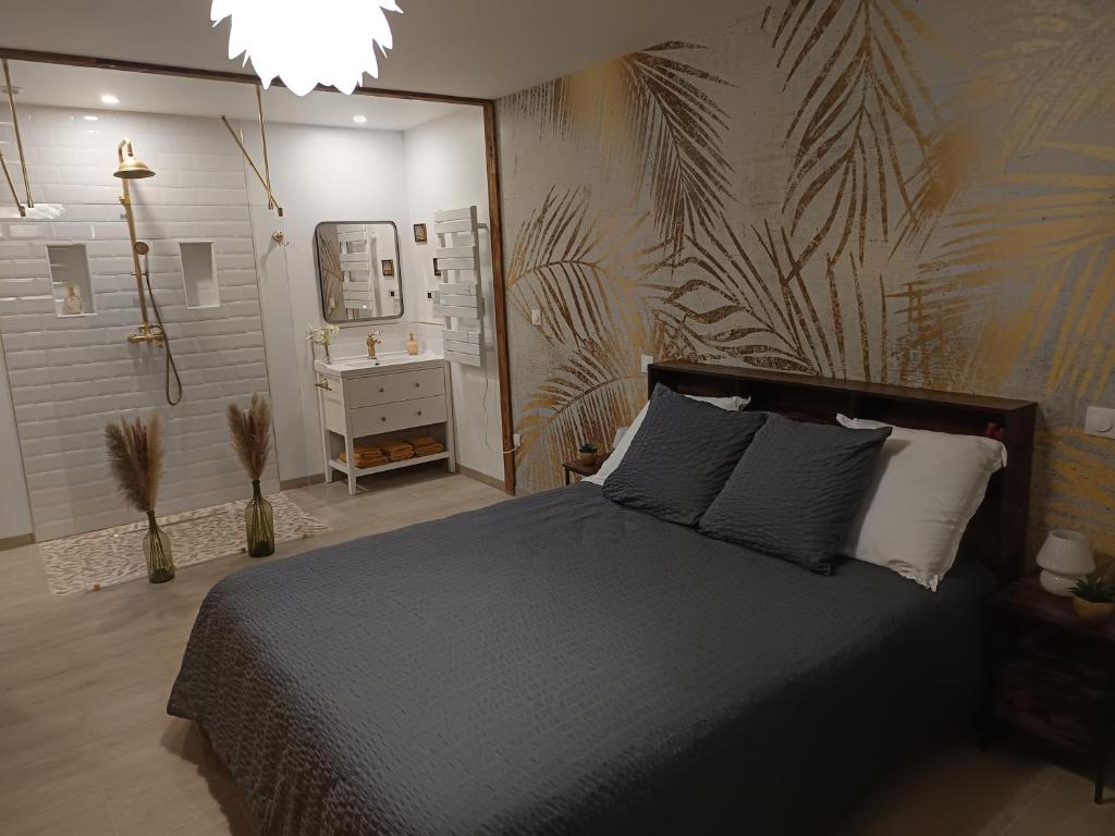 una camera da letto con un letto grande e un bagno di L'atelier Détente et Spa a Caudrot