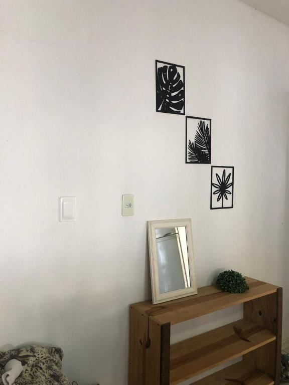 a mirror on top of a wooden shelf on a wall at Casa Grande aconchegante in Joinville