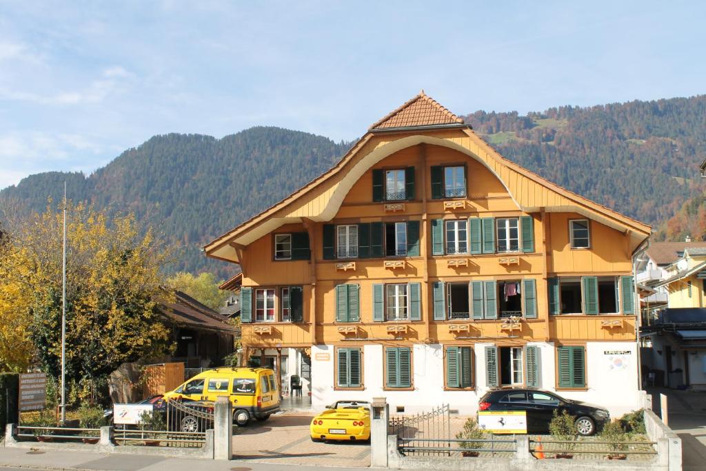 una grande casa con macchine parcheggiate di fronte di Residence Jungfrau a Interlaken