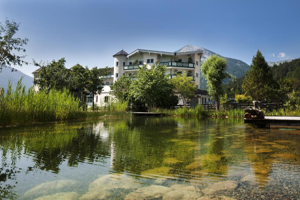 un edificio sul lato di un lago di Familienparadies Sporthotel Achensee - FAMILIES ONLY ad Achenkirch