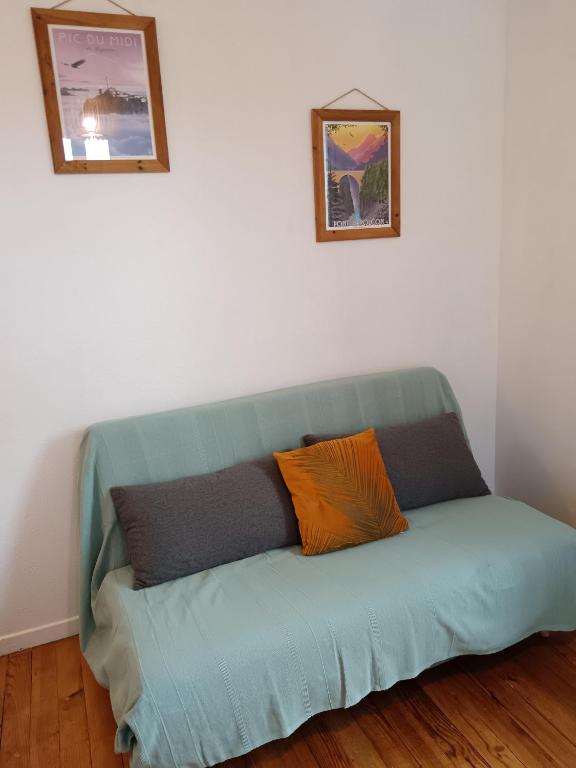 - un canapé vert dans une pièce avec deux oreillers dans l&#39;établissement T2 Coeur d&#39; Argelès-Gazost, tout à pied, à Argelès-Gazost