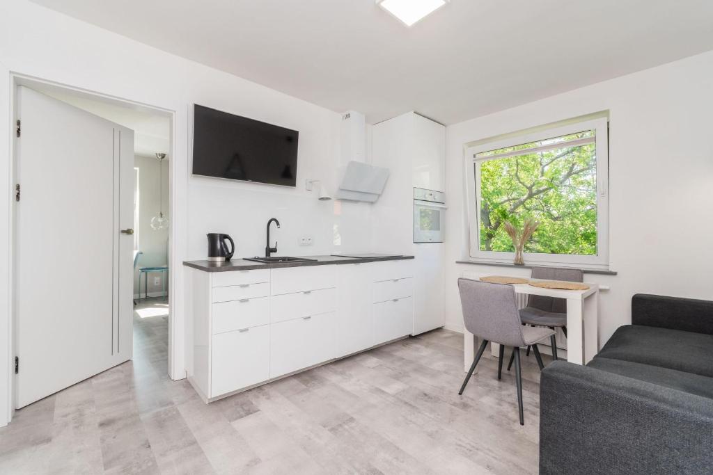 ソポトにあるSzary & Zielony by Grand Apartmentsのソファとテーブルのあるキッチンとリビングルーム