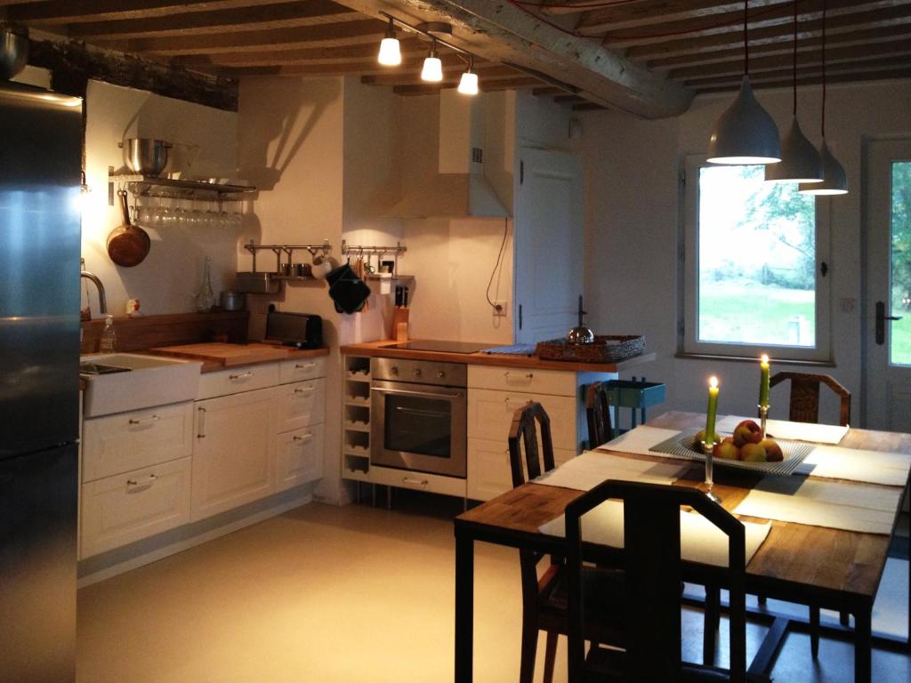a kitchen with a table and a dining room at L'oisellerie Cottages in Le Renouard