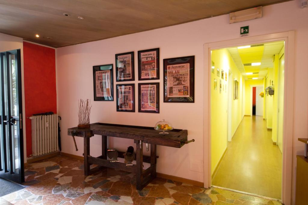 um corredor com uma mesa numa parede com fotografias em Luci A San Siro em Milão