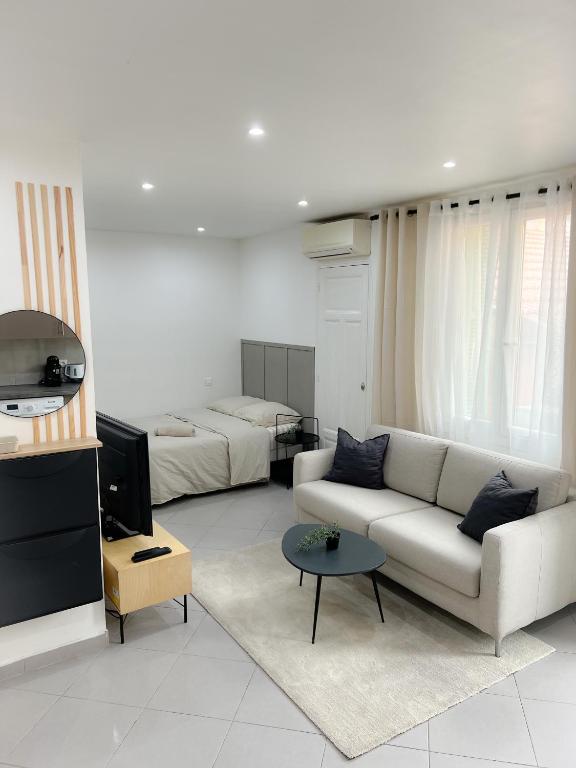 un salon avec un canapé et un lit dans l'établissement République, à Nice