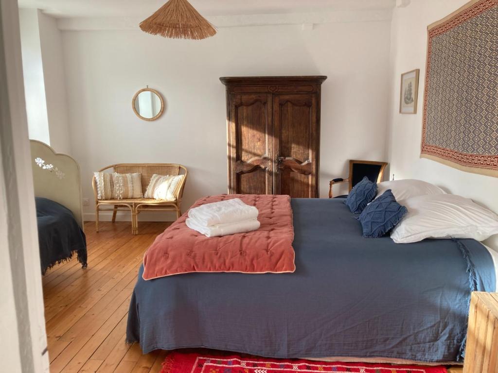 a bedroom with a blue bed with two pillows at Grande maison - village de Noyers - 5 chambres in Noyers-sur-Serein