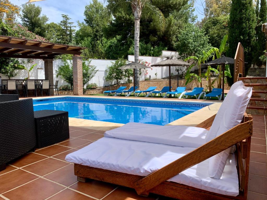 una cama junto a una piscina en Villa Pelae, en Frigiliana