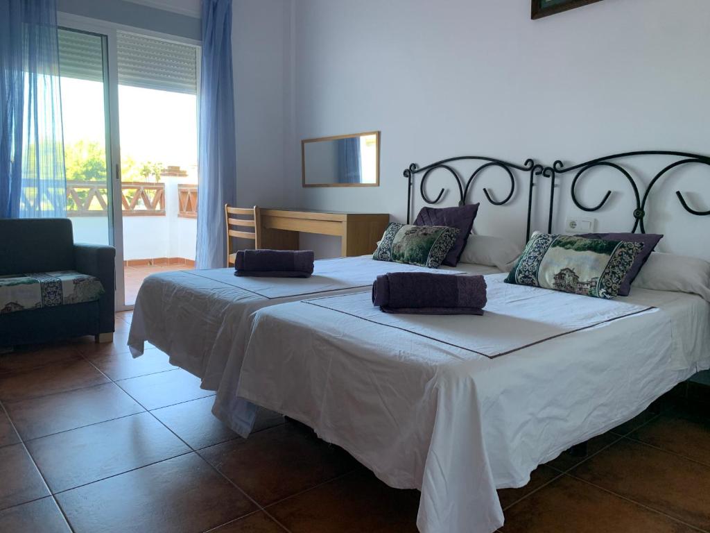 1 dormitorio con 2 camas y 1 silla en Villa Pelae, en Frigiliana