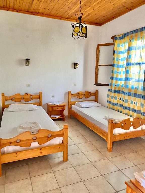 a bedroom with two beds and a chandelier at Betsanis Stafylos Apartments in Stafylos