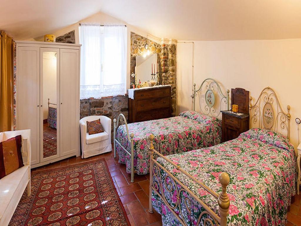 1 dormitorio con 2 camas y espejo en Al Vecchio Metato, en Valgiano