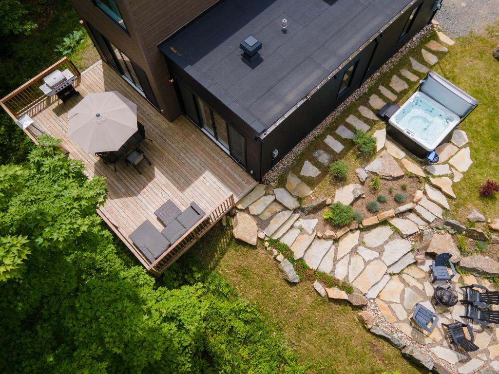 an overhead view of a house with a deck and a swimming pool at Chalet Listra peace & spa - 16 min to Tremblant in La Conception