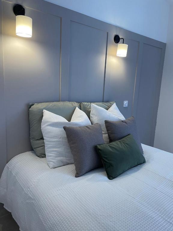 un lit avec un tas d'oreillers dessus dans l'établissement Duplex raffiné, élégant & climatisé - La MEZZ, à Nîmes