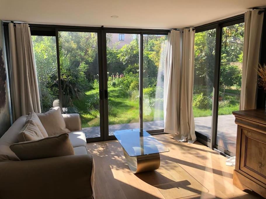 un salon avec un canapé et une table en verre dans l'établissement Rez-de-jardin à 15 min de Paris, à Alfortville