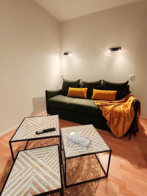 - un salon avec deux tables et un canapé dans l'établissement Grand studio face mer, à Saint-Georges-de-Didonne