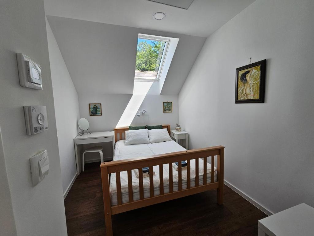 Habitación en el ático con cama y ventana en Hadam's Apartments, en Bled