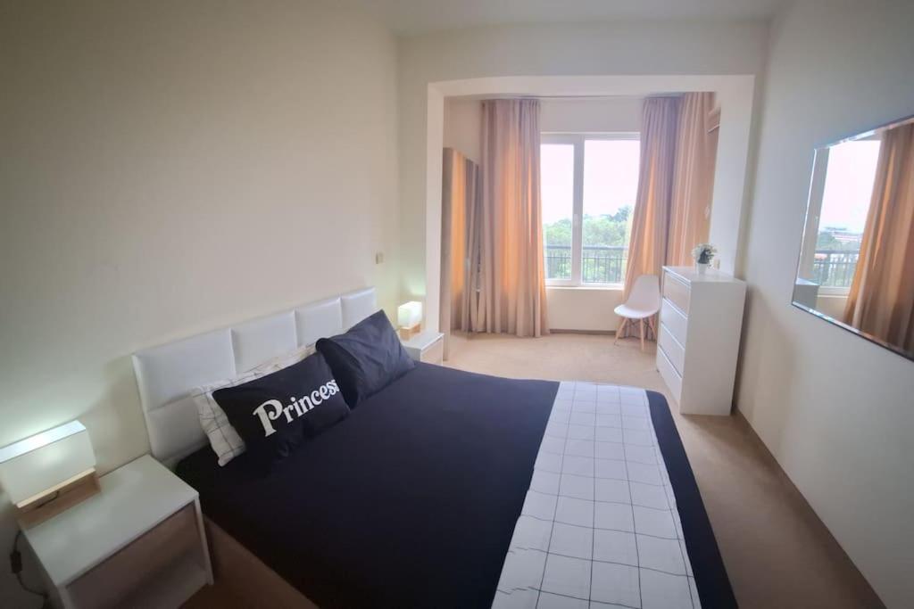 een slaapkamer met een zwart-wit bed en een raam bij golden sands flat 147 in Goudstrand