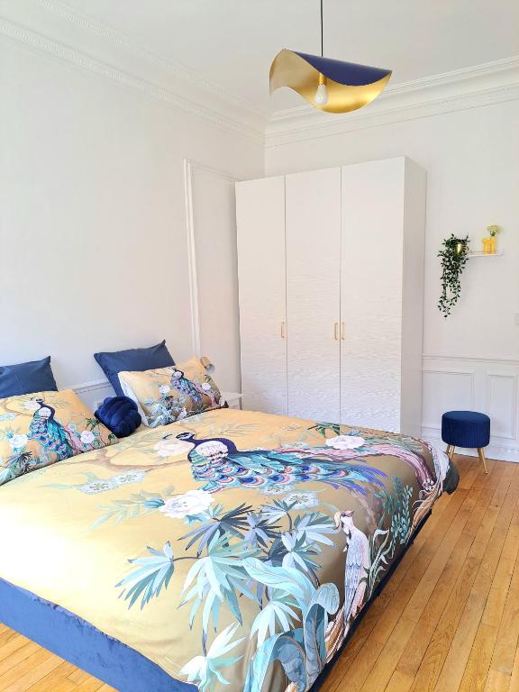 une chambre avec un lit avec une couette colorée dans l'établissement L'Instant Rémois - Hypercentre Boulingrin, à Reims