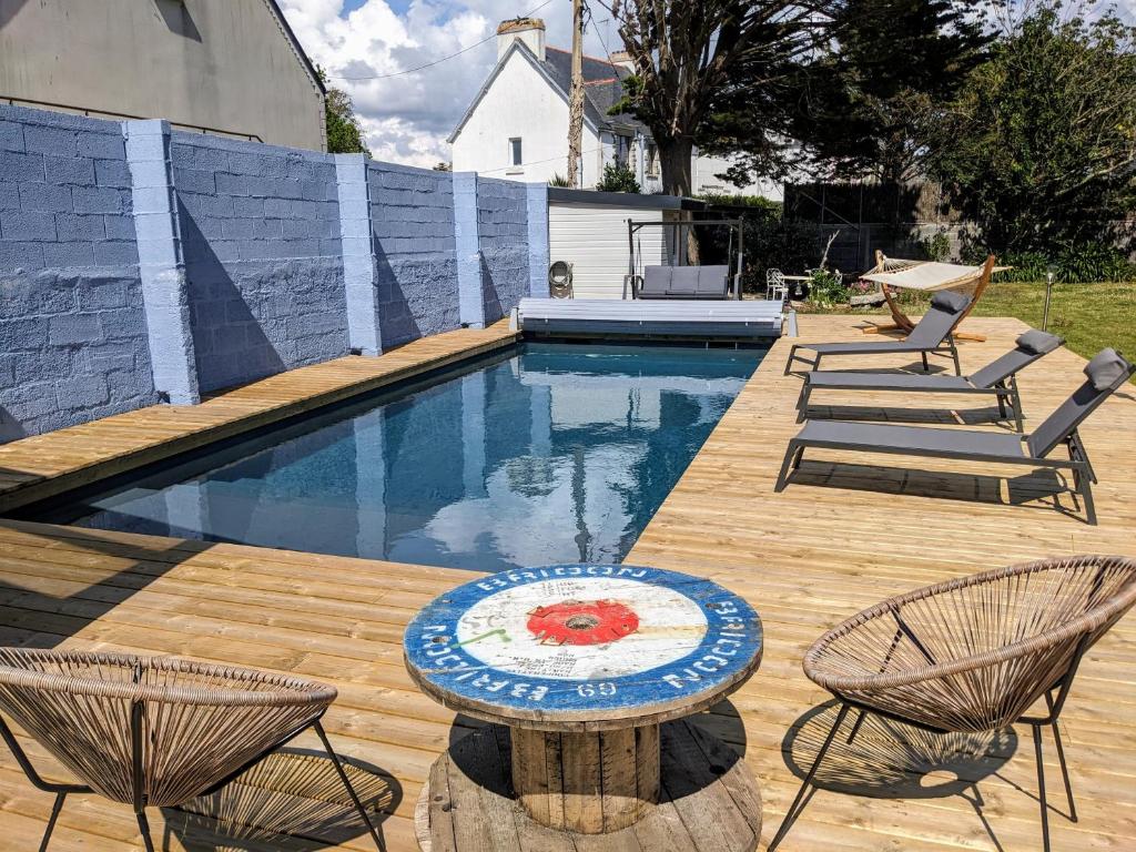 une piscine avec deux chaises et une table à côté dans l'établissement Ty glaz- Piscine privé chauffé securisé -Plage 700m, au Guilvinec