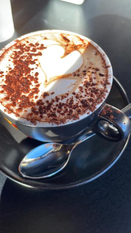 a cup of coffee on a plate with a spoon at EtnaMare petite maison in Mascali
