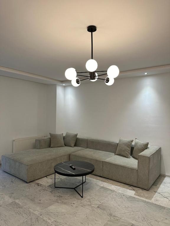 a living room with a couch and a chandelier at Glamorous Spacious 3BR at Jardin de Carthage Tunis in Sidi Daoud